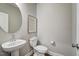 Compact powder room with pedestal sink, round mirror, and standard toilet at 9513 Wood River Dr, Zebulon, NC 27597