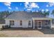 Rear view of the home highlighting the screened porch and a large, treed backyard at 9513 Wood River Dr, Zebulon, NC 27597