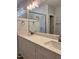 Bathroom featuring a double sink vanity with stylish faucets, a large mirror, and modern shower at 987 Lewis Rd, Zebulon, NC 27597