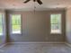 Bedroom with natural light streaming through two windows, complemented by a ceiling fan at 987 Lewis Rd, Zebulon, NC 27597