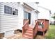 A wooden deck and stairs leading to a backyard with white siding on a sunny day at 109 Troyer Pl, Apex, NC 27502