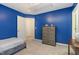 Cozy bedroom featuring a bed, dresser, and view to the next room through an open door at 109 Troyer Pl, Apex, NC 27502