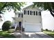 Two-story home features a white garage door and black shutters against light siding under a bright, sunny sky at 109 Troyer Pl, Apex, NC 27502