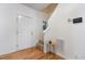 Bright foyer with hardwood floors, a white front door, and staircase with carpeted steps at 109 Troyer Pl, Apex, NC 27502