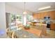 Charming kitchen featuring stainless steel appliances, wood cabinets, island, and an adjacent dining area with sliding door access at 109 Troyer Pl, Apex, NC 27502