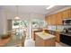 Well-equipped kitchen with wood cabinets, island, stainless steel appliances, and an adjacent dining area with outdoor access at 109 Troyer Pl, Apex, NC 27502