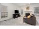 Living room with large windows, a fireplace, gray sofa, and modern entertainment center at 109 Troyer Pl, Apex, NC 27502