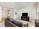Carpeted living room with a gray sofa, a black TV stand, and a view of the front entry at 109 Troyer Pl, Apex, NC 27502