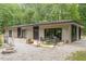 Backyard featuring a patio and fire pit surrounded by gravel with a modern home and green trees at 1115 Sepelo Way, Efland, NC 27243