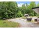 Picturesque backyard featuring patio area, fire pit and shed surrounded by lush, mature trees at 1115 Sepelo Way, Efland, NC 27243