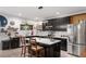 Modern kitchen featuring stainless steel appliances, sleek black cabinetry, and stylish breakfast bar seating at 1115 Sepelo Way, Efland, NC 27243