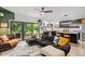 Open-concept living room featuring a modern kitchen, comfortable seating, and large windows to the backyard at 1115 Sepelo Way, Efland, NC 27243