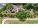 Aerial view of a beautiful home with manicured lawn, surrounded by trees, and a fire pit area at 112 Lancaster Dr, Chapel Hill, NC 27517