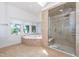 Modern bathroom features a glass enclosed shower and a soaking tub near a window at 112 Lancaster Dr, Chapel Hill, NC 27517
