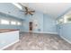Bright bonus room featuring a ceiling fan, skylights, and a side entry door at 112 Lancaster Dr, Chapel Hill, NC 27517