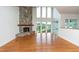 Open living room with a stone fireplace and large windows, providing natural light and scenic views at 112 Lancaster Dr, Chapel Hill, NC 27517