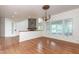 Bright living area with hardwood floors, decorative wallpaper, chandelier, and stone fireplace in the background at 112 Lancaster Dr, Chapel Hill, NC 27517