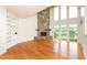 Spacious living room featuring a stone fireplace and large windows offering ample natural light and scenic views at 112 Lancaster Dr, Chapel Hill, NC 27517