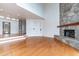 Open living room featuring hardwood floors, a stone fireplace, built-in shelving, and an entryway at 112 Lancaster Dr, Chapel Hill, NC 27517