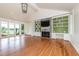 Bright living room with built-in shelving, a stone fireplace, hardwood floors, and large windows for natural light at 112 Lancaster Dr, Chapel Hill, NC 27517