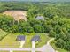 Aerial view of two homes surrounded by lush trees and a tranquil pond at 115 Jensen Dr, Wendell, NC 27591