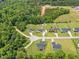 An aerial view shows homes with green lawns in a wooded neighborhood, with a new road under construction at 115 Jensen Dr, Wendell, NC 27591