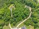 Aerial view showcasing homes surrounded by dense trees and winding roads in a serene, wooded neighborhood at 115 Jensen Dr, Wendell, NC 27591