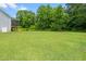 Spacious backyard with lush green grass and mature trees providing a serene and private outdoor space at 115 Jensen Dr, Wendell, NC 27591
