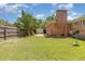 A grassy backyard with a brick house, a brick patio, and a wood fence at 1304 Park Ave, Dunn, NC 28334