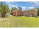 Expansive green backyard featuring a brick house, a shed and mature trees at 1304 Park Ave, Dunn, NC 28334
