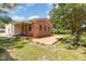 A brick house with a paved patio, greenery, and a hint of summer blooms at 1304 Park Ave, Dunn, NC 28334