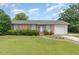 Charming brick home featuring a well-maintained lawn, attached garage, and colorful shutters at 1304 Park Ave, Dunn, NC 28334