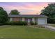 Charming brick home featuring a well-maintained lawn, attached garage, and colorful shutters at 1304 Park Ave, Dunn, NC 28334