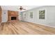 Bright living room features a brick fireplace, wood-look flooring, and large windows at 1304 Park Ave, Dunn, NC 28334