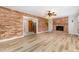 Open-concept living room featuring a brick fireplace, wood-look floors, and access to the kitchen at 1304 Park Ave, Dunn, NC 28334