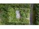 Secluded property surrounded by lush trees, with a gray roof and paved access road at 134 Chateau Rd, Durham, NC 27704