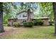Rear view of a home with a brick facade, a sliding glass door, and a tree-lined perimeter at 134 Chateau Rd, Durham, NC 27704