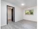 An empty bedroom with gray floors, a window letting in lots of natural light, and a dark door at 134 Chateau Rd, Durham, NC 27704