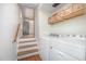 Laundry room with washer and dryer units; cabinets mounted above them. Stairs in background at 134 Chateau Rd, Durham, NC 27704