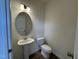 Bathroom with pedestal sink, oval mirror, and modern fixtures at 136 Bruce Dr Dr, Dunn, NC 28334