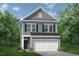 Charming two-story home with a gray exterior, complemented by a two-car garage and manicured landscaping at 136 Bruce Dr Dr, Dunn, NC 28334