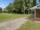 A spacious backyard featuring a chain link fence and a combination of grass and gravel surfaces at 1413 Chamblee Rd, Zebulon, NC 27597