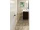 Clean bathroom featuring a dark vanity with a sink, tile flooring, and a window at 1413 Chamblee Rd, Zebulon, NC 27597