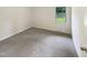 Neutral bedroom with carpeted floors, white walls, and a bright window at 1413 Chamblee Rd, Zebulon, NC 27597