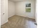 Small bare bedroom with carpet, a window, and a door at 1413 Chamblee Rd, Zebulon, NC 27597