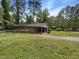 A cozy brick home with a fenced yard and surrounded by mature trees and a green lawn at 1413 Chamblee Rd, Zebulon, NC 27597