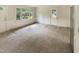 A spacious living area with large windows, a door, carpet and an exterior view at 1413 Chamblee Rd, Zebulon, NC 27597