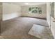 Empty living room showing spacious layout, ample natural light, and neutral carpet at 1413 Chamblee Rd, Zebulon, NC 27597