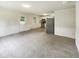 Open floor plan with living area leading to kitchen, stainless steel appliances and bright lighting at 1413 Chamblee Rd, Zebulon, NC 27597