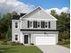 Charming two-story home featuring a two-car garage, black shutters, and a well-maintained lawn at 153 Gladstone Loop, Clayton, NC 27520